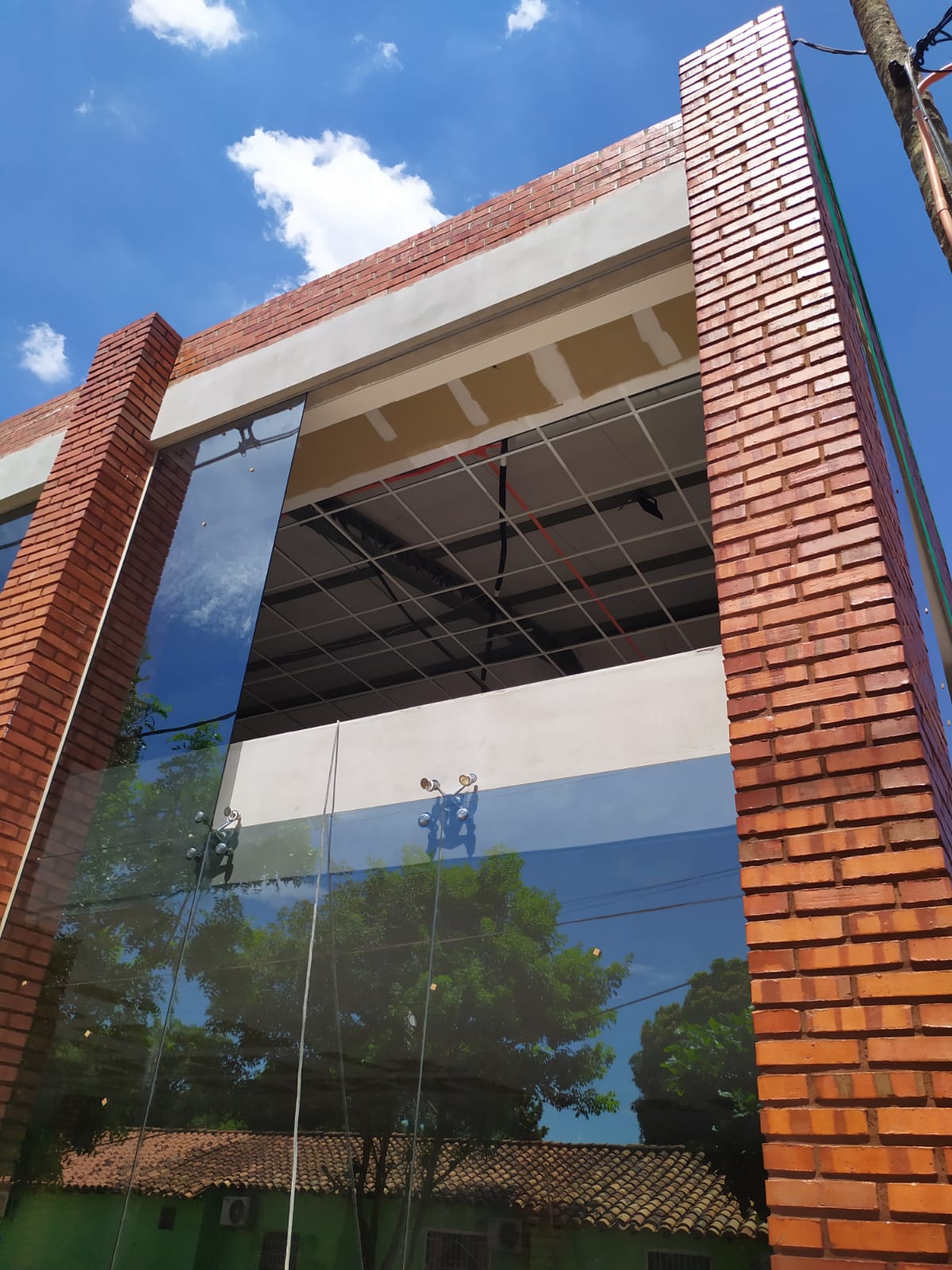 Muro cortina de vidrio en fachada de edificio con ladrillo visto — MÁS VIDRIOS