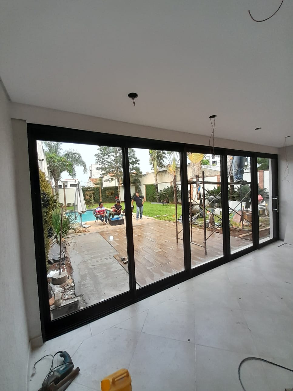 Cerramiento de vidrio corredizo con marco de aluminio negro hacia el jardín — MÁS VIDRIOS