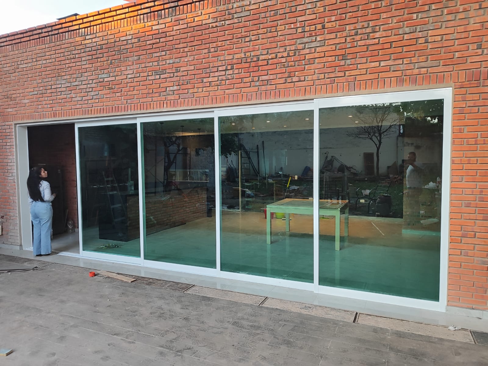 Vidriera corrediza de gran formato en fachada de ladrillo visto — MÁS VIDRIOS